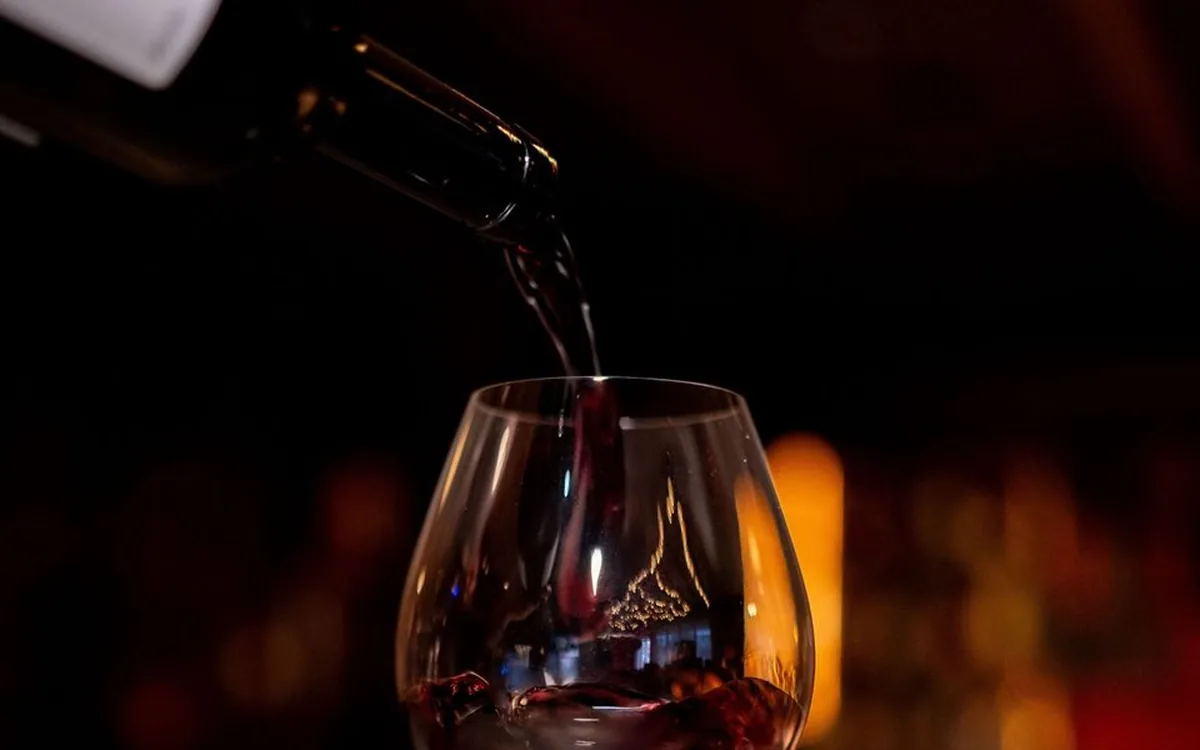 A glass of red wine poured tableside at Enology Wine Bar and Bistro